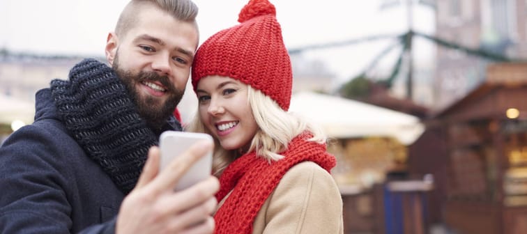 A couple takes a selfie at an outdoor market.