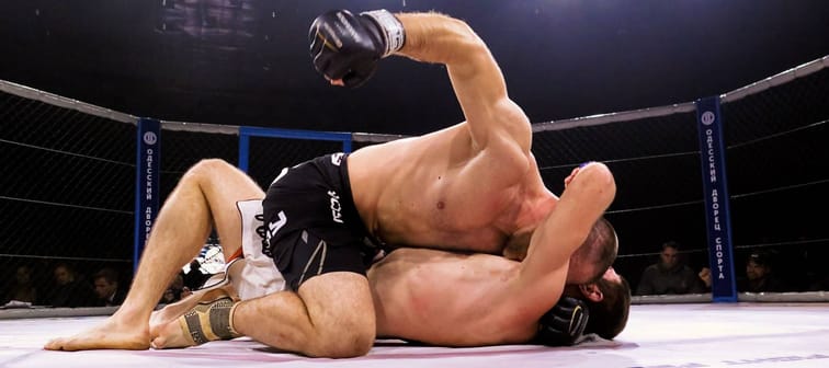 Odessa, Ukraine - 24 November 2015: Athletes in the ring extreme Sport mixed martial arts competition tournament series  "World MMA Network MAXMIX". The dramatic moment of battle punches
