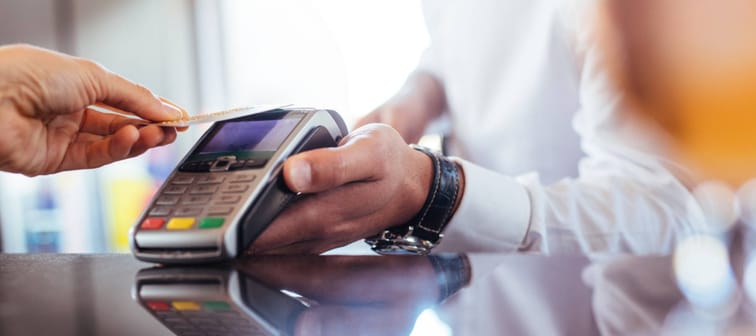 hand of customer paying with contactless credit card with NFC technology