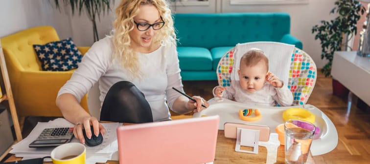 Women at home working with her infant next to her