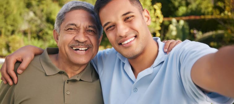 A father and son take a portrait outdoors.