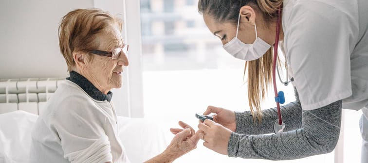 A medical professional takes an elderly woman's blood pressure.