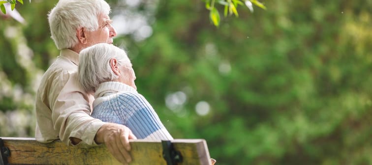 Elderly couple resting on a bench in the park