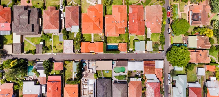 Fine geometry of modern local living suburb of Chatswood in Sydney's North Shore in aerial overhead view over house roofs, back yards, pools and parked cars on the streets.