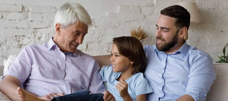 Senior grandpa, millennial father and pre teen boy enjoying family leisure time on couch.