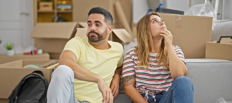 Man and woman couple sitting on floor stressed at new home
