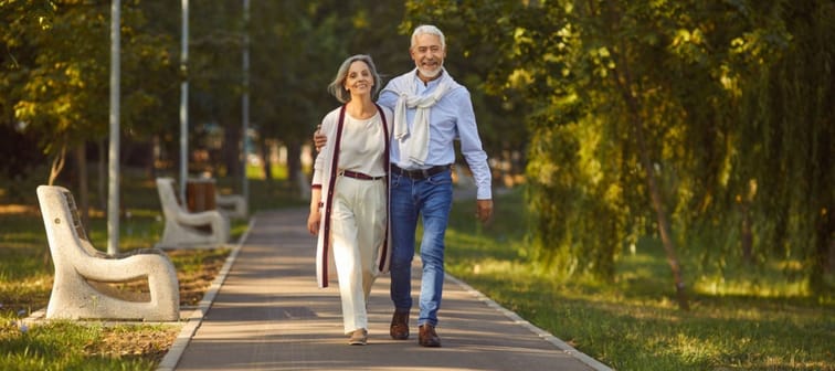 Happy older couple walking in a park