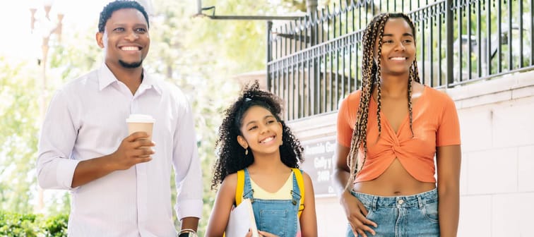 A father and mother take their daughter to school.