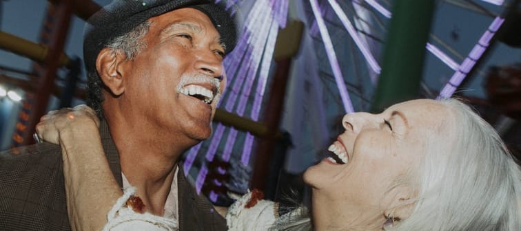 A cheerful couple enjoy their time at an amusement park.