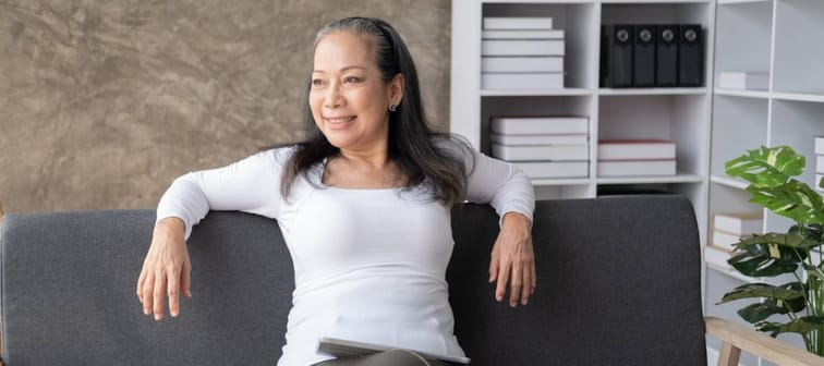 Calm relaxed mature older woman relaxing sitting on couch at home.