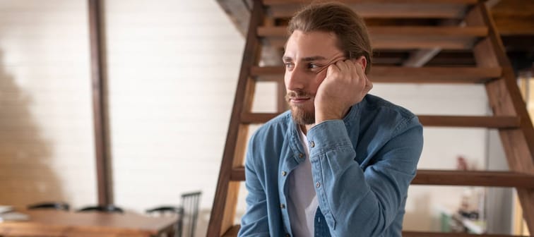 Tired of communication. A bored and tired man holding his smartphone