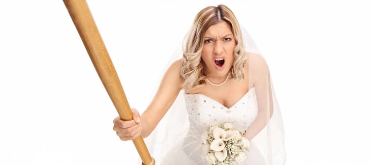 Angry young bride holding a baseball bat and yelling