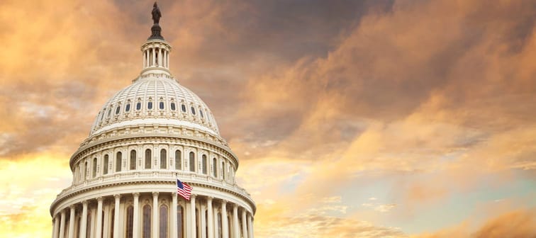 United States Capitol building with a fiery sky in the background.