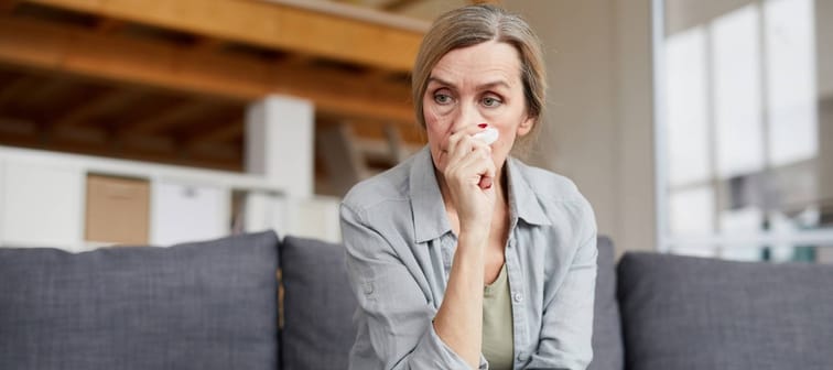 Mature woman staring into space on couch