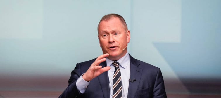Nicolai Tangen seen wearing a suit and headset, talking on stage.