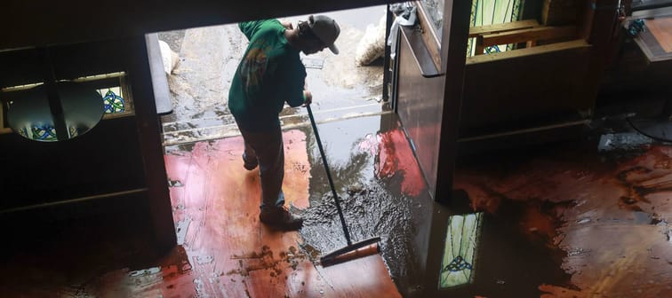 Austin Stolpe clears the mud from the floor of the Celtic Ray Public House restaurant/bar.