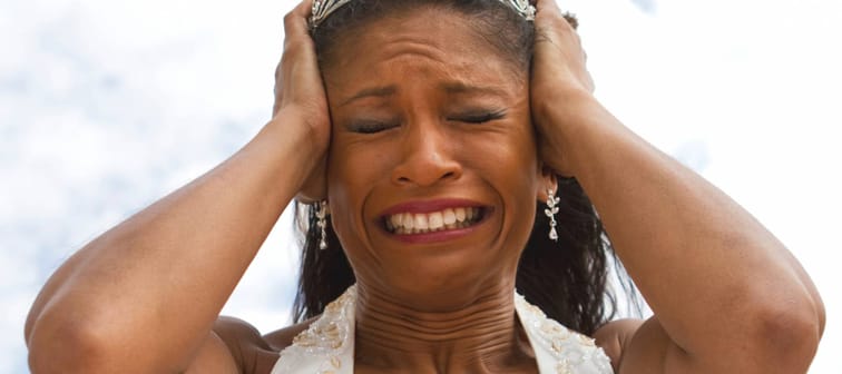 A woman holds her head in distress