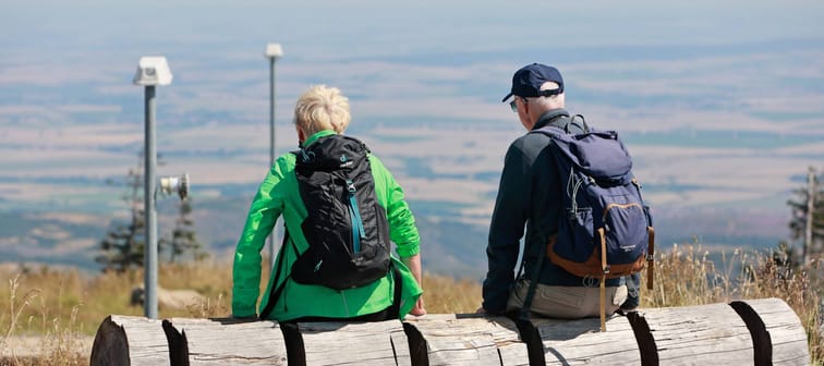 Retired backpackers enjoy a mountain view.