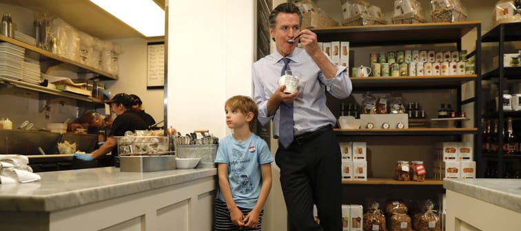 Gov. Gavin Newsom eats a parfait as his son Hunter, then 8, waits for his oatmeal inside Rustic Bakery in Larkspur, California.