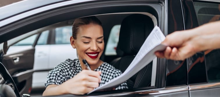 Satisfied and smiled female buyer sitting in her new car.