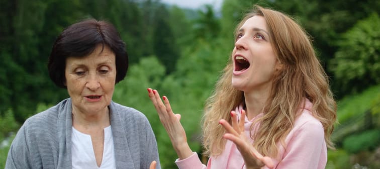 Outdoors portrait of senior mother and adult daughter are communicating