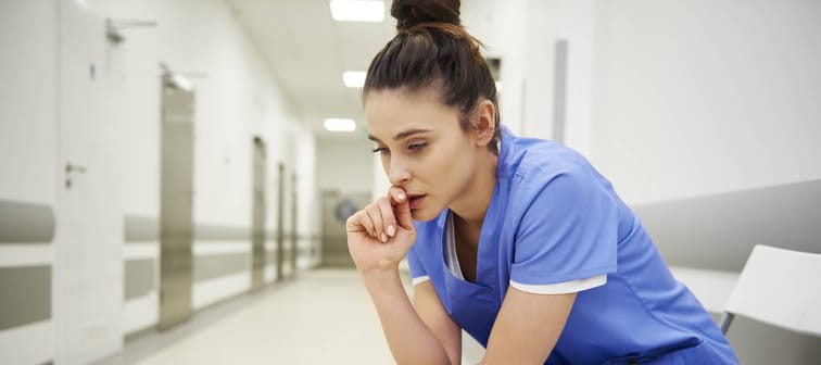 Nurse in hospital sitting on a chair hunched over