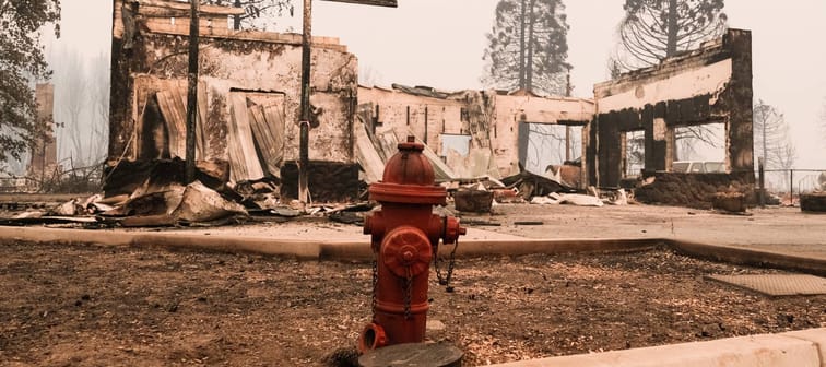A red fire hydrant sits in front of the remains of a structure destroyed by the Dixie Fire that is situated along Highway 89 on August 8, 2021 in Greenville, California.