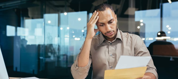 A man is stressed reading a letter.