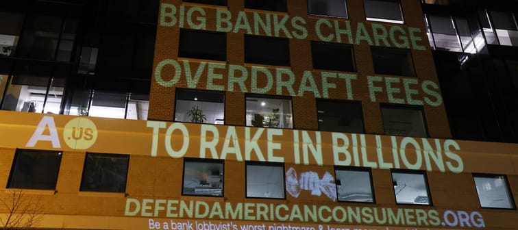 A anti-overdraft-fee graphic projected on a building.