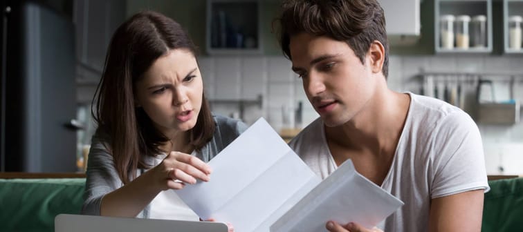 Couple looks at utility bill.