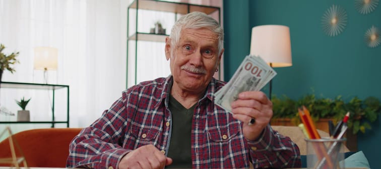 Senior citizen flashing cash.