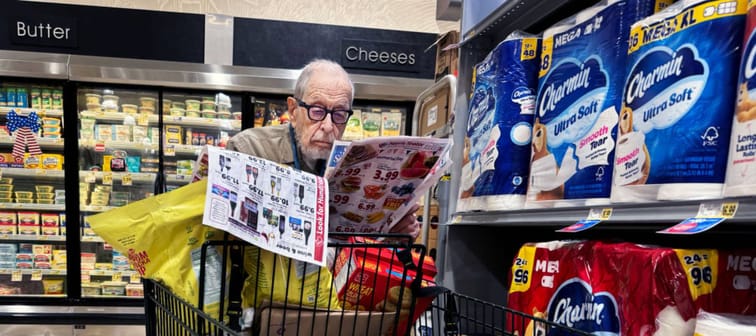 Senior man scans flyer in Washington, D.C., grocery store.