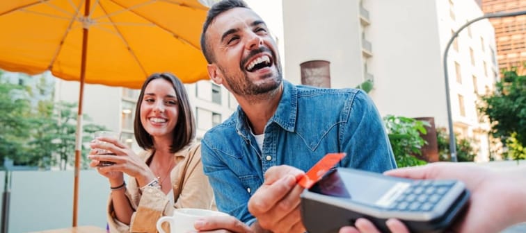 Couple paying for meal with a debit card.