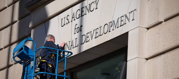 A worker removes the U.S. Agency for International Development sign from its headquarters in Washington, D.C., Feb. 7, 2025.