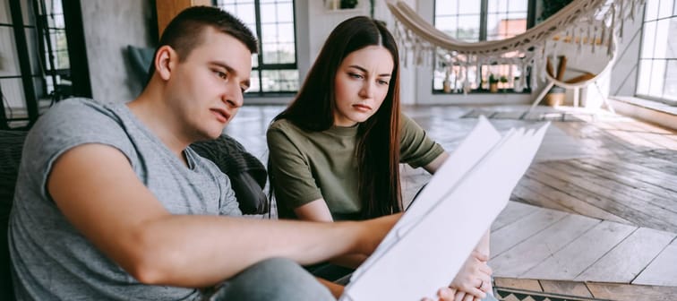 A young couple looking at paperwork in a house