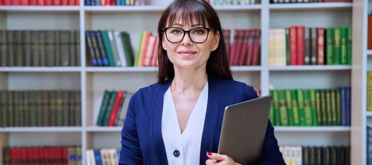 Teacher standing with book.