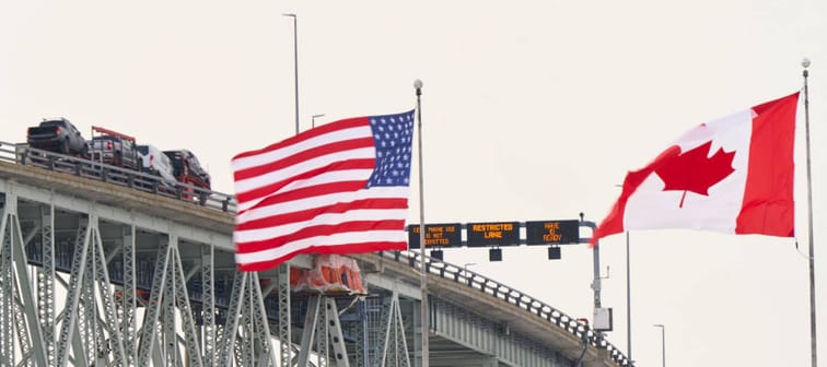 The US and Canadian flags fly on the US side of the St. Clair River near the Bluewater Bridge border crossing