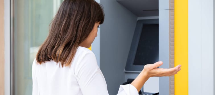 Seemingly annoyed woman at a bank ATM.