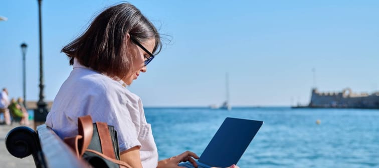 Business mature woman sitting outdoor using laptop.