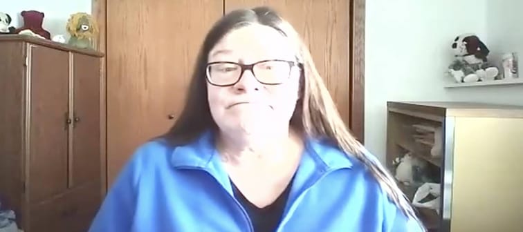 Woman frowns on video call.