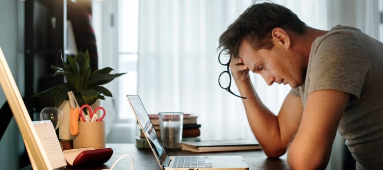 Man stressed while working on laptop