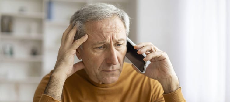 Senior man on hold on his cell phone