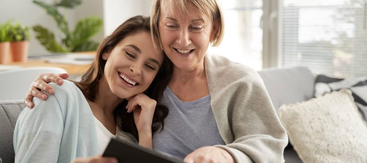 Mother and adult daughter looking at family photo album