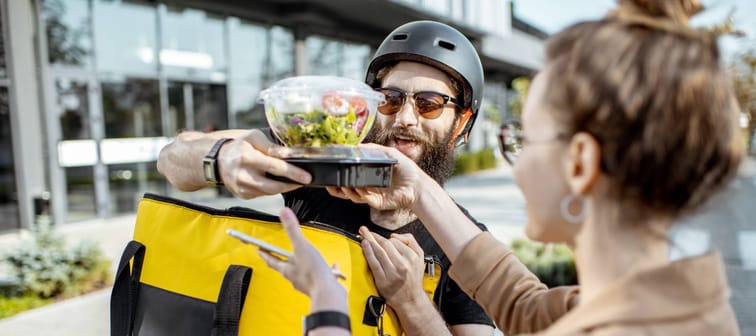 Woman getting food from delivery person