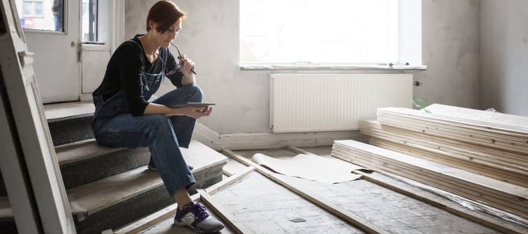 Woman looking at her phone while renovating her home