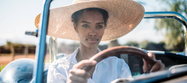 A young woman driving a convertible.