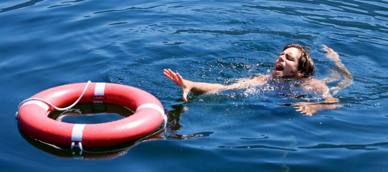 A man struggling for a life buoy in the water