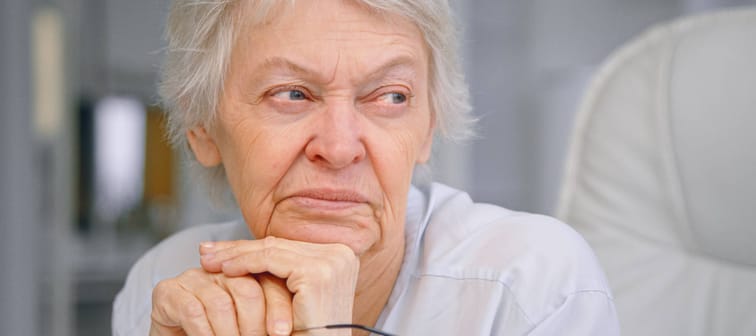 An older woman sits in thought.
