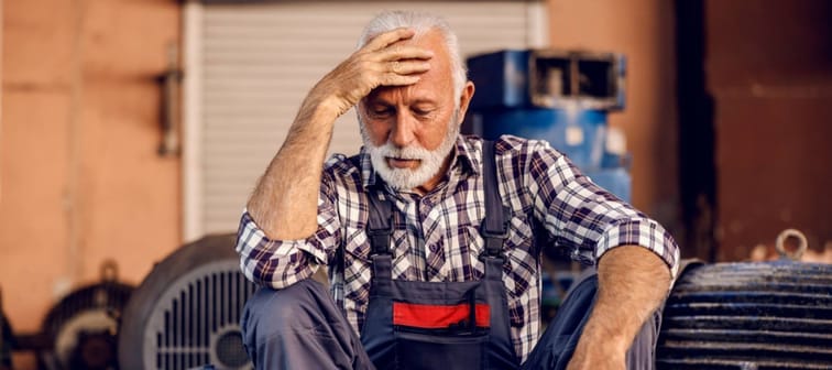 A sad senior factory worker