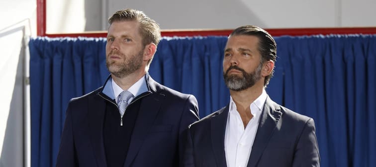 Eric Trump (L) and Donald Trump Jr. standing side-by-side at a rally.